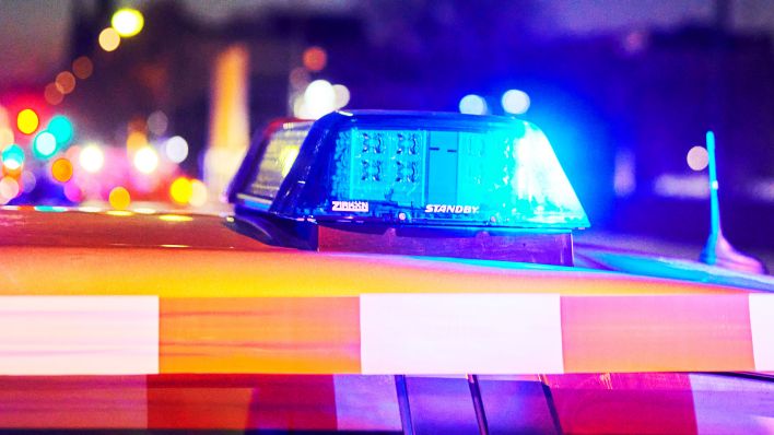 Das Blaulicht eines Polizeiwagens hinter einem Absperrband, leuchtet. (Quelle:dpa/A.Riedl)
