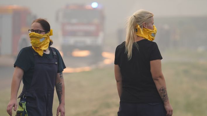 Einsatzkräfte der Feuerwehr tragen wegen der starken Rauchentwicklung bei einem Waldbrand bei Beelitz Mundschutz (Quelle: DPA/Jörg Carstensen)