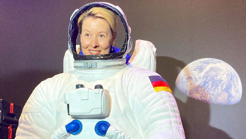 Franziska Giffey (SPD), Regierende Bürgermeisterin in Berlin, steht während eines Presserundgangs auf der Internationalen Luft- und Raumfahrtausstellung (ILA) hinter einem Astronatenanzug.(Quelle: dpa/B.Fraune)