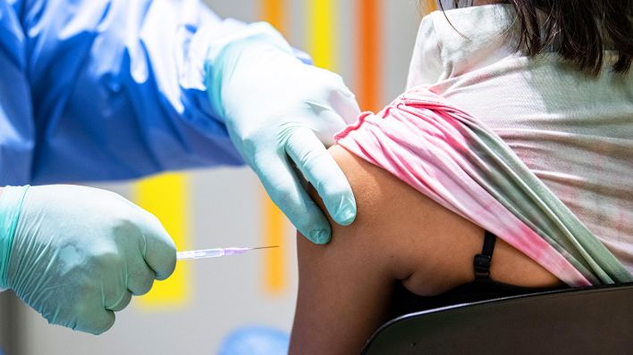 Symbolbild: Eine Person wird von einem Impfarzt gegen das Coronavirus geimpft. (Quelle: dpa/F.Sommer)