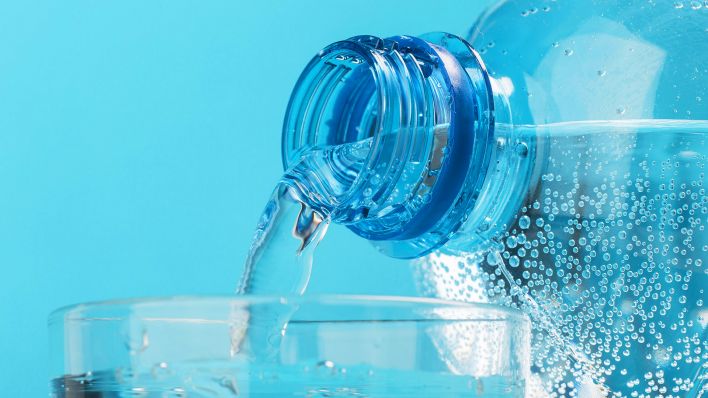 Mineralwasser wird aus einer Flasche in ein Glas gegossen. (Quelle: dpa/O.Latkun)