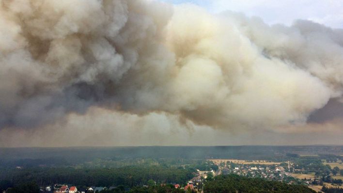 Eine große Rauchwolke steigt wegen eines Waldbrandes auf (Aufnahme mit Drohne). Das Feuer sei außer Kontrolle, womöglich drohe eine Evakuierung von Beelitz, sagte der Bürgermeister. (Foto: Christian Guttman/dpa)