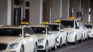 Taxi-Fahrzeuge stehen vor dem BER-Terminal. (Quelle: dpa/Andreas Franke)
