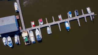 Boote liegen an einem Holzsteg. (Quelle: dpa/Stephan Schulz)