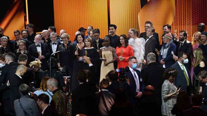 Die Preisträger stehen nach der Verleihung des Deutschen Filmpreises 2021 „Lola“ auf der Bühne neben Kulturstaatsministerin Monika Grütters (l, CDU). (Quelle: dpa/Soeren Stache)