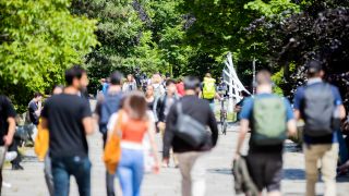 Menschen gehen beim Studierendenwerk Berlin über den Uni-Campus. (Quelle: dpa/Christoph Soeder)