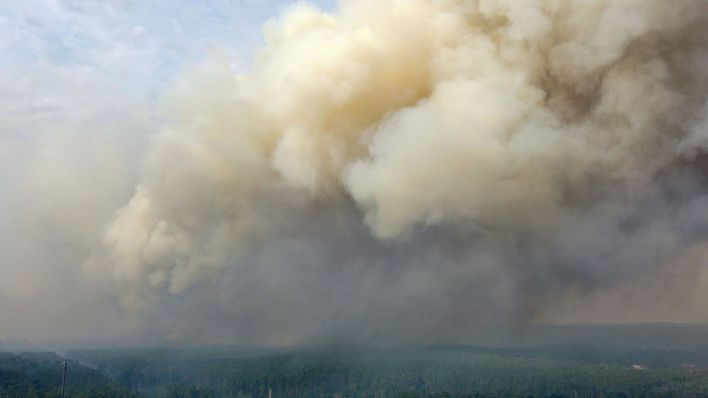 Symbolbild: Eine große Rauchwolke steigt wegen eines Waldbrandes auf. (Quelle: dpa/Christian Guttmann)