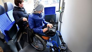 Eine Person im Rollstuhl in einem Zug in Brandenburg. (Quelle: dpa/Bernd Settnik)