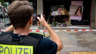 Ein Polizist fotografiert die beschädigte Ladenfront am Unfallort. Am Vortag war ein 29-jähriger hier mit seinem Auto in der Nähe der Berliner Gedächtniskirche in eine Schülergruppe aus Hessen gefahren, deren Lehrerin ums Leben kam. (Quelle: dpa/F. Sommer)