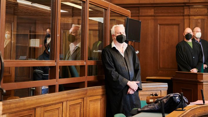 Der 29-jährige Angeklagte (l, halb verdeckt) sitzt bei Prozessbeginn im Kriminalgericht Moabit hinter einer Scheibe (Bild: dpa/Annette Riedl)
