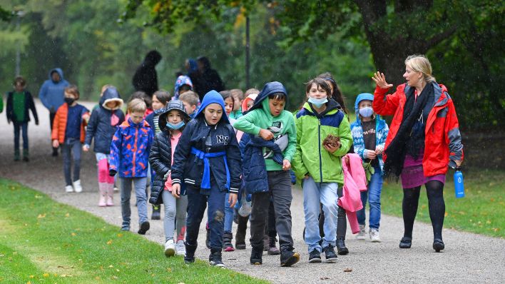 Symbolbild: GrundschuelerInnen machen bei Regen eine Wanderung ins Gruene. (Quelle: dpa/S. Simon)