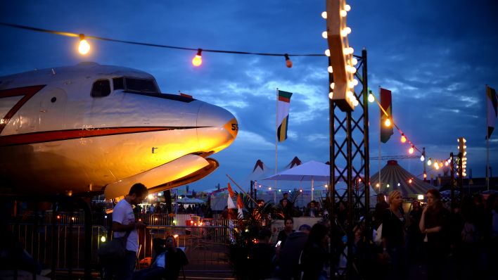 Besucher des Lollapalooza Festivals gehen am 13.09.2015 über das Gelände des ehemaligen Flughafen Tempelhof in Berlin (Quelle: dpa/Pedersen)