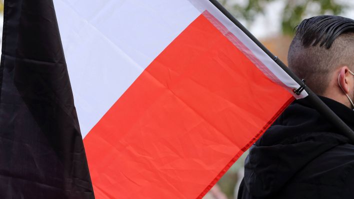 Ein Teilnehmer mit einer schwarz-weiß-roten Reichsflagge während einer Demonstration in Potsdam (Bild: imago images/Martin Müller)