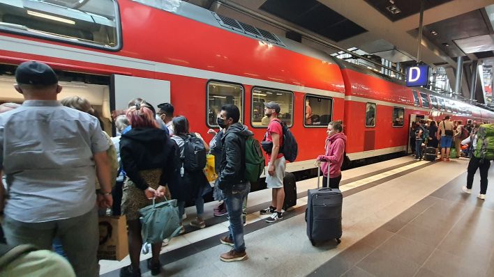 Menschen steigen am Berliner Hauptbahnhof in einen Regionalexpress