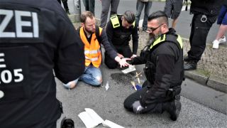 Polizeibeamte lösen Theodor Schnarr mit Speiseöl von der A103. (Foto: Marcel Trocoli Castro/rbb)