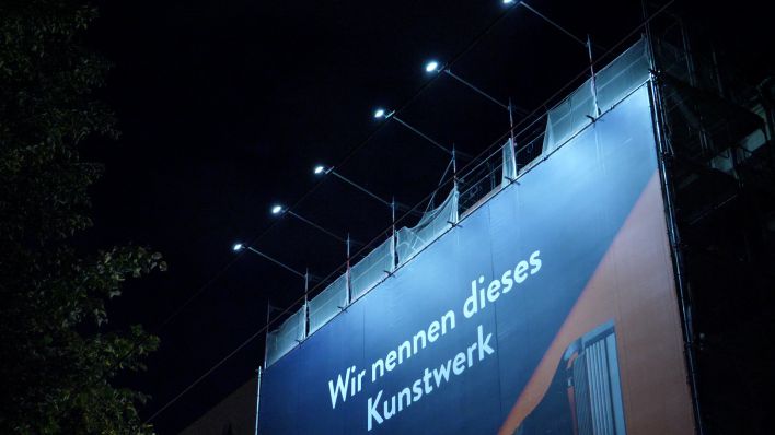 Ein Riesenposter an einem Haus in der Warschauer Straße wird nach 22 Uhr beleuchtet. (Bild: rbb/Naomi Donath)