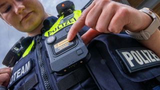 Archivbild: Ihre neue Body-Cam schaltet Polizeiobermeisterin Maria Potratz bei der Vorstellung des neuen Systems ein. (Quelle: dpa/Jens Büttner)