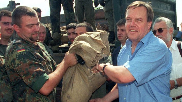Verteidigungsminister Volker Rühe (r) packt am 6.8.1997 bei einem Besuch seiner Truppen am Oderdeich bei Vogelsang beim Aufladen von Sandsäcken mit an. (Quelle: dpa/Torsten Silz)