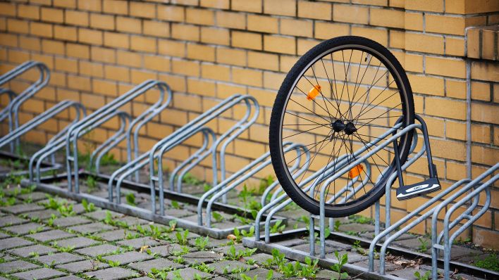 Archivbild: Ein Vorderrad steht angeschlossen an einem Fahrradständer am 23.07.2011 in Berlin. (Quelle: dpa/Thomas Trutschel)