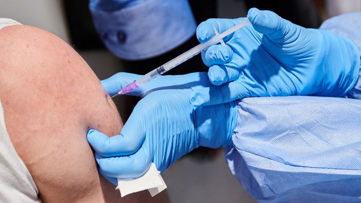 Symbolbild: Eine Ärztin impft am 03.12.2021 einen Mann in Berlin. (Quelle: dpa/Annette Riedl)