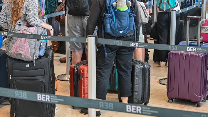 Reisende warten am 06.07.2022 an einem Check-in für ihren Abflug vom Hauptstadtflughafen Berlin Brandenburg (BER). (Quelle: dpa/Patrick Pleul)