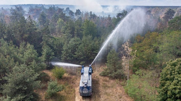Ein Wasserwerfer der Brandenburger Polizei löscht einen Waldbrand in Elbe-Elster (Quelle: dpa/Jan Woitas)