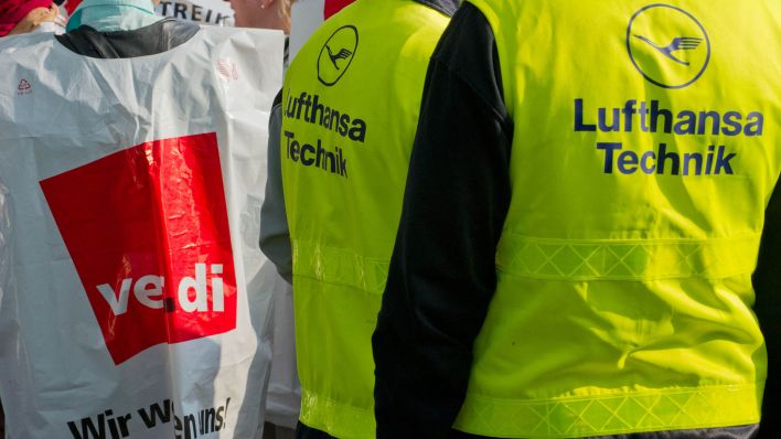 ARCHIV - Mitarbeiter der Lufthansa stehen am 22.04.2013 vor einem Eingang des Flughafens in Berlin. (Quelle: dpa/ Tim Brakemeier)
