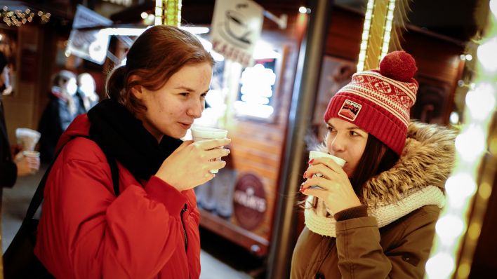 Zwei Frauen trinken in der Schlossstraße beim Weihnachtsshopping einen Glühwein (Quelle: DPA/Kay Nietfeld)