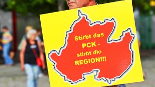 Ein Mann trägt ein Schild mit der Aufschrift «Stirbt das PCK - stirbt die Region!!!» auf der Demonstration des Bürgerbündnisses «Zukunft Schwedt». (Quelle: dpa/P.Pleul)