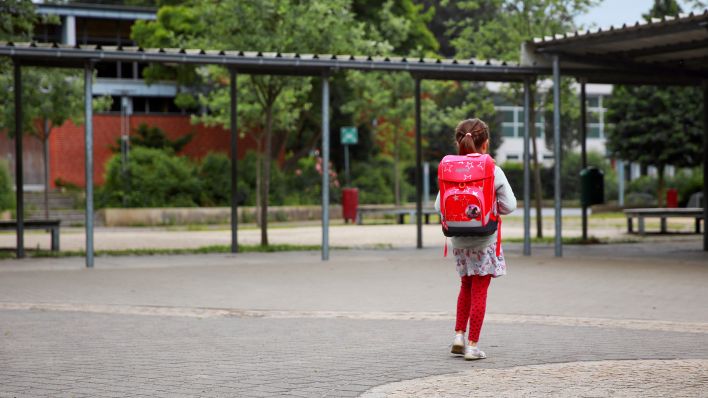 Symbolbild: Ein Mädchen geht über einen Schulhof. (Quelle: dpa/M.Brichta)