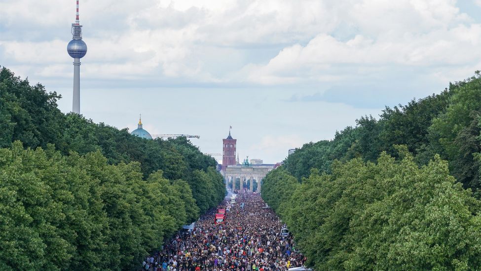 Unter dem Motto «Rave the Planet» zieht eine Parade aus Technofans tanzend am Brandenburger Tor vorbei (Bild: dpa/Jörg Carstensen)