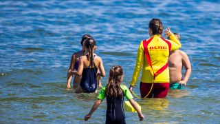 Eine Rettungsschwimmerin geht mit Kindern zum Schwimmkurs der DLRG ins Wasser. (Quelle: picture alliance/dpa/dpa-Zentralbild | Jens Büttner)