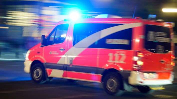Symbolbild: Ein Rettungswagen der Feuerwehr bei einer Einsatzfahrt mit Blaulicht. (Quelle: dpa/Geisler)
