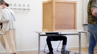 Mann mit gebrochenem Fuss in der Wahlkabine (Quelle: dpa/Jens Krick)