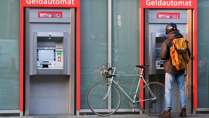 Ein Kunde steht vor zwei Geldautomaten der Berliner Sparkasse. (Quelle: Jens Kalaene/dpa)