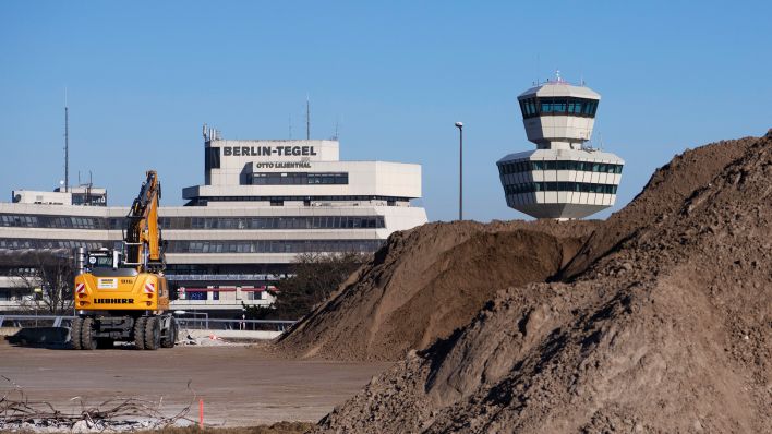 Archivbild: Der Tower des ehemaligen Flughafen Tegel ist hinter einem riesigen Erdhügel zu sehen. (Quelle: dpa/P. Zinken)