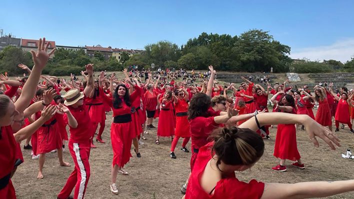 Teilnhemer, die wie Sängerin Kate Bush im Musikvideo «Wuthering Heights» in Rot gekleidet sind, tanzen beim Flashmob «The Most Wuthering Heights Day Ever» im Görlitzer Park. (Quelle: dpa/Tanja Hellmig)