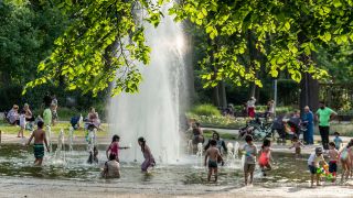 Sommer in Berlin, Familien am Springbrunnen im Treptower Park bei schönem Wetter (Quelle: imago images/Jürgen Held)