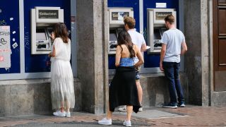 Menschen stehen vor Geldautomaten der Volksbank (Quelle: imago-images/Michael Gstettenbauer)