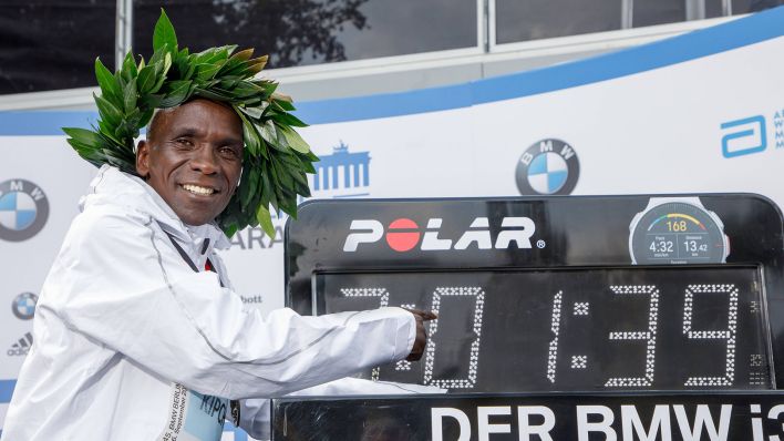 Eluid Kipchoge präsentiert stolz seine Weltrekord-Zeit beim Berlin-Marathon 2018 (imago images/Norbert Wilhelmi)