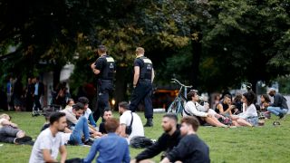 Polizisten laufen durch die Besucher des James-Simon-Parks in Berlin-Mitte. (Quelle: imago-images/Future Image)
