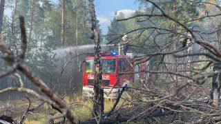 Einsatzkräfte der Feuerwehr löschen den Brand in der Lieberoser Heide am 04.07.2022. (Quelle: rbb/Josefine Jahn)