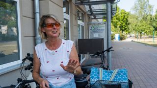 Die Strausbergerin Antje Fischer, die seit 35 Jahren in der Stadt am Straussee lebt, steht vor ihrem Fahrrad, 20.07.2022 (Quelle: rbb / Hinze).