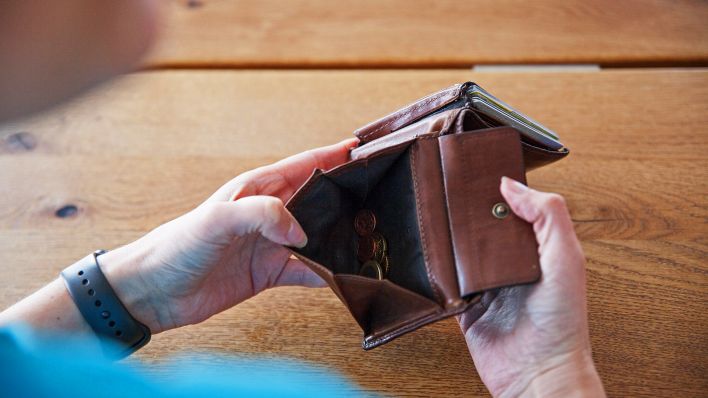 Symbolbild:Eine Frau hält ein Portemonnaie in den Händen, in der Geldbörse sind verschiedene Euro-und Centstücke.(Quelle:dpa/K.Schmitt)