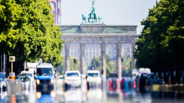 Die Hitze erzeugt ein Flimmern über der Straße des 17. Juni vor dem Brandenburger Tor. (Quelle: dpa/C.Soeder)