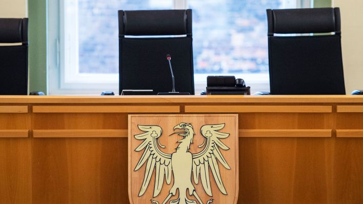 Blick in einen leeren Verhandlungssaal mit dem Brandenburger Adler im Landgericht von Cottbus.(Quelle:dpa/P.Pleul)