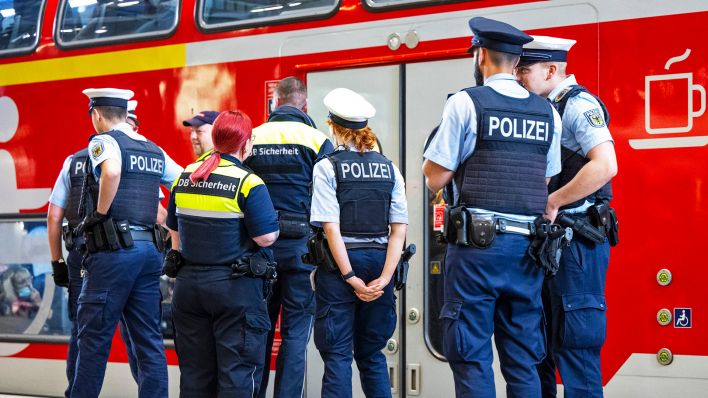 Polizisten und Mitarbeiter von DB Sicherheit stehen an einem Bahnsteig.(Quelle:dpa/M.Skolimowska)