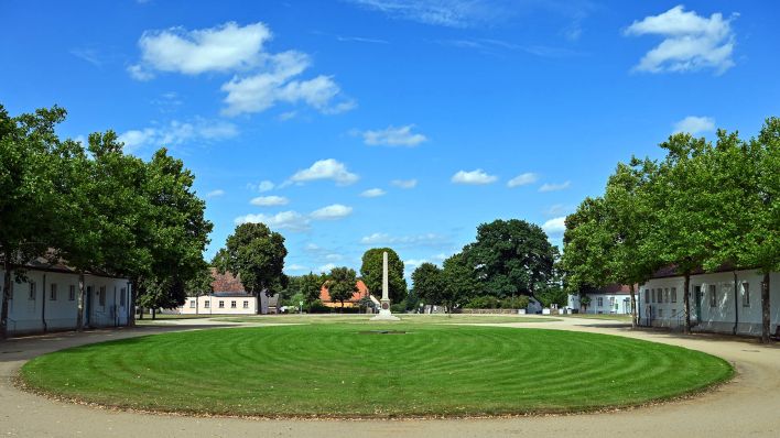 Eine runde Rasenfläche und ein Obelisk vor dem Schloss Neuhardenberg.(Quelle:dpa/P.Pleul)
