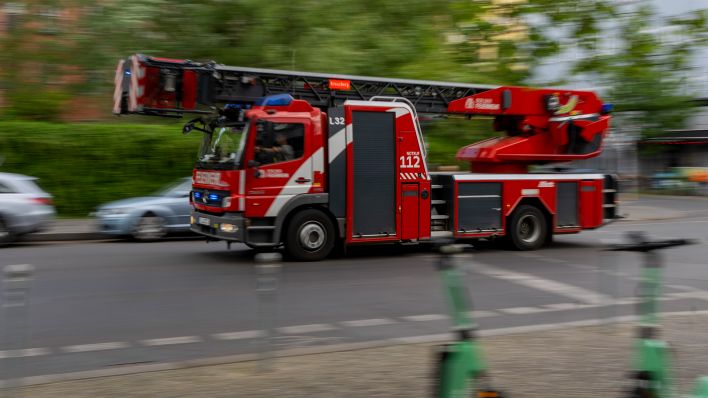 Ein Feuerwehrauto fährt mit Blaulicht zum Einsatz. (Quelle: dpa/Monika Skolimowska)