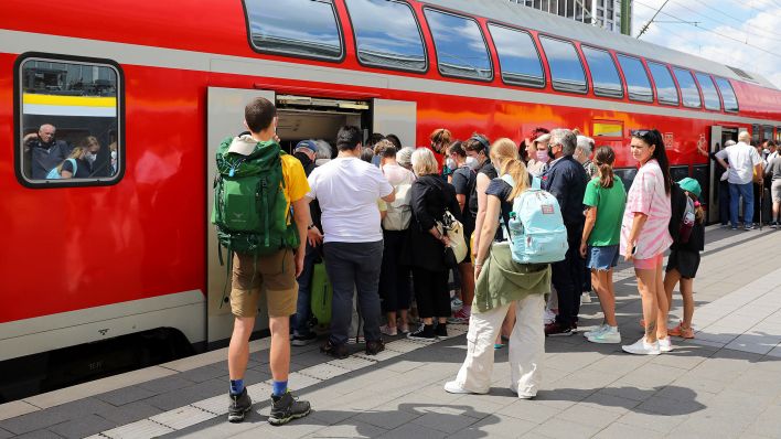 Fahrgäste warten in einer Schlange am Bahnsteig auf den Einstieg in den Regionalexpress. (Quelle: dpa/Micha Korb)